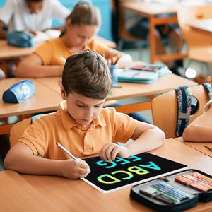 Child using 20-inch LCD drawing board with colorful glowing letters in classroom setting