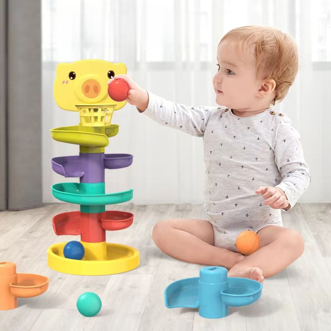 Baby playing with interactive baby basketball stacking toy with colorful ramps and balls on wooden floor