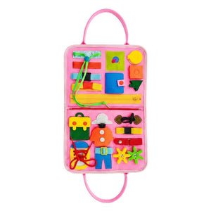 Toddler playing with Little Hands & Big Minds Busy Book featuring zippers, buttons, buckles, and a movable clock in a soft handbag design